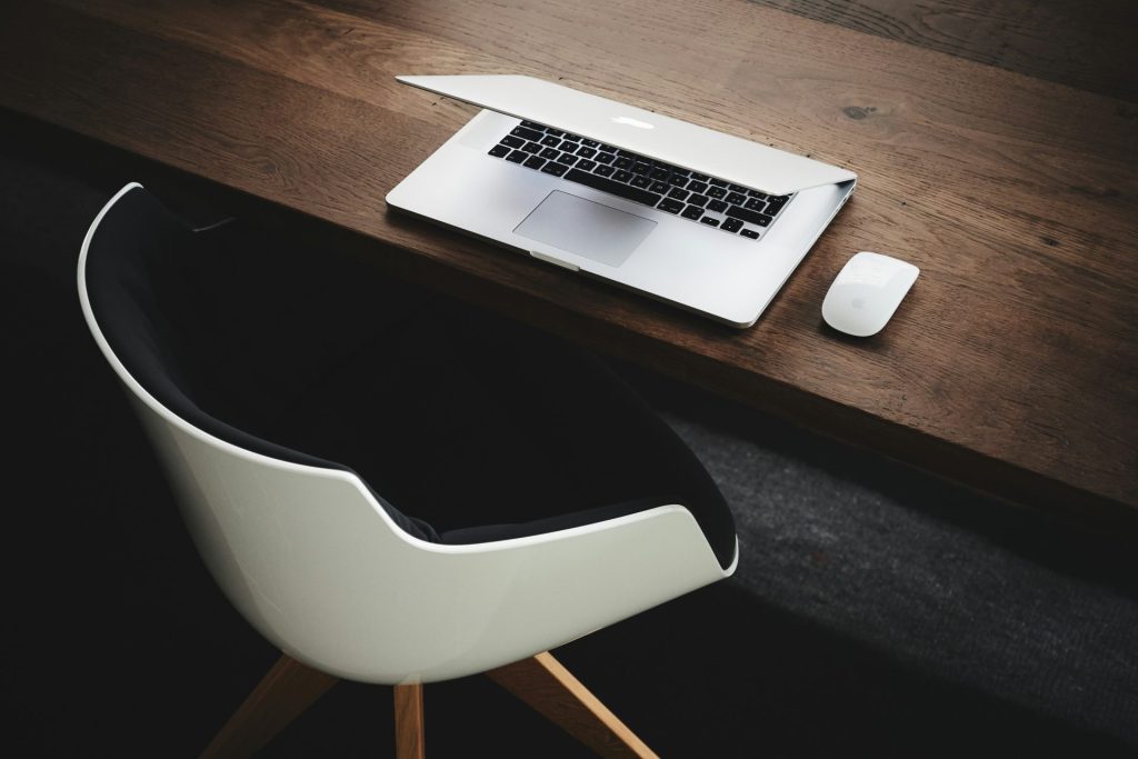 Apple MacBook à côté de la souris d'ordinateur sur la table